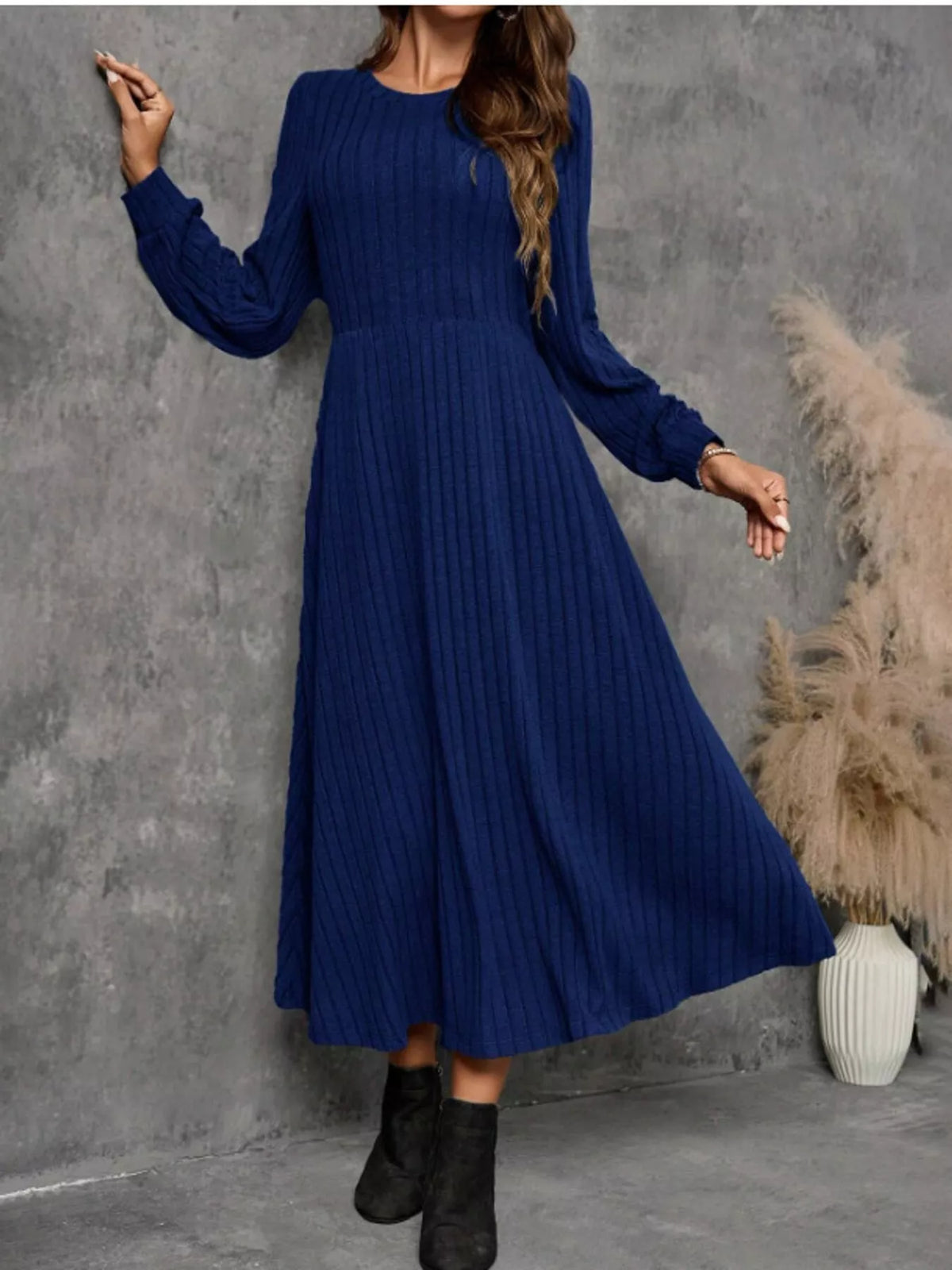 Royal Blue ribbed knit long-sleeve A-line midi dress on a model, with the hem swinging to one side.