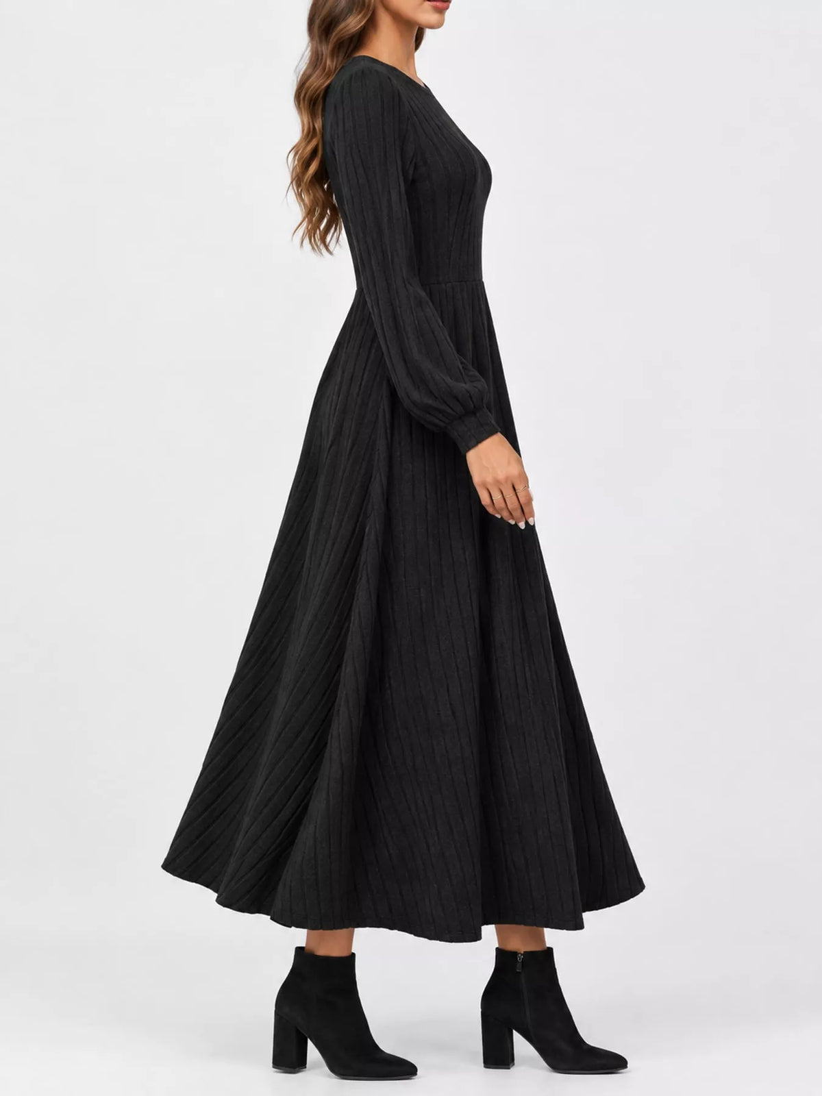Black ribbed knit long-sleeve A-line midi dress, side view on model against a white background.
