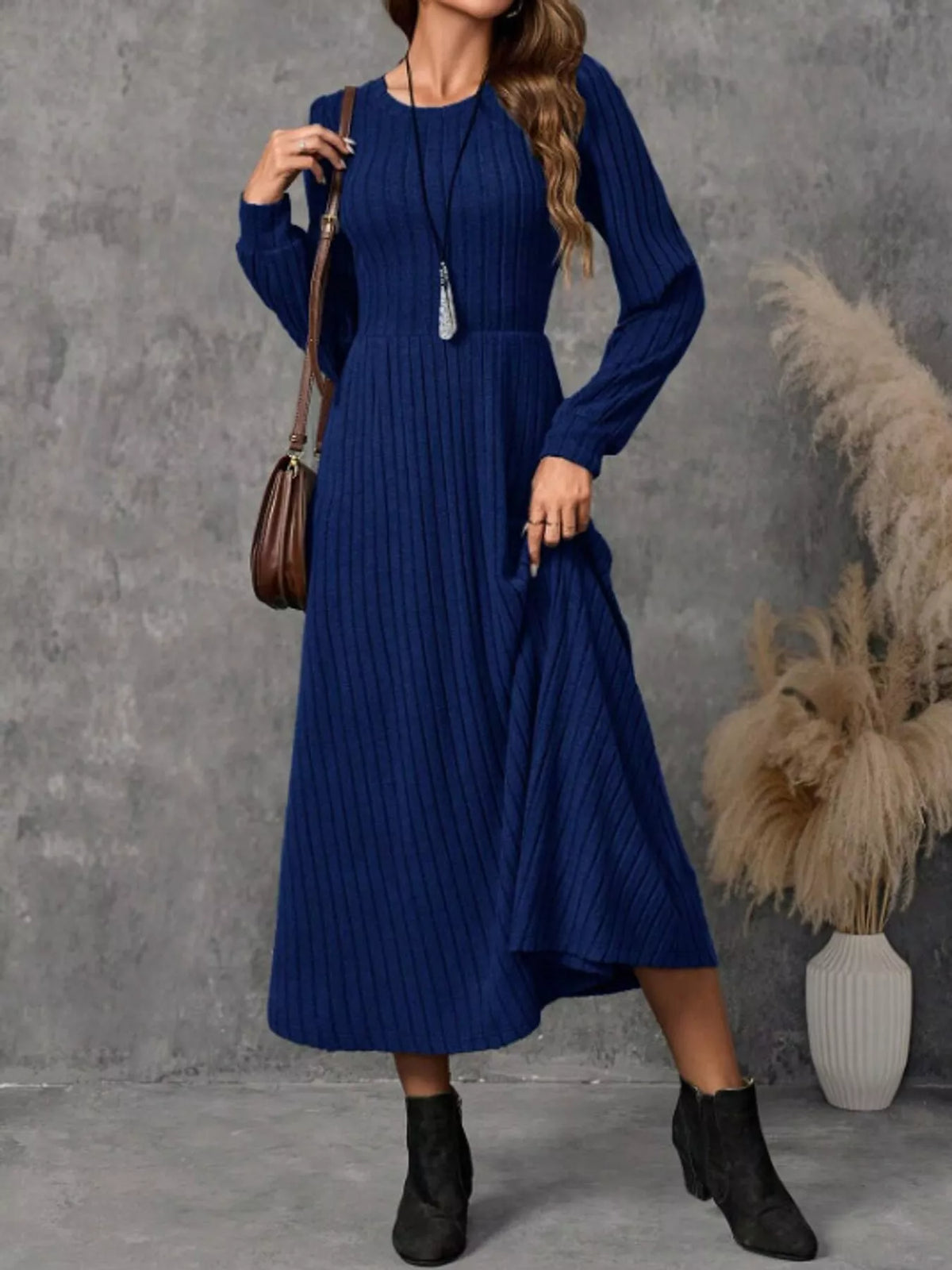 Royal Blue ribbed knit long-sleeve A-line midi dress on a model holding the hem to one side.